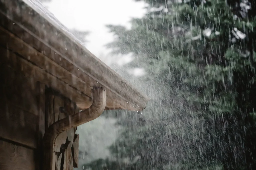 A rainstorm hitting the gutters of a wooden house.