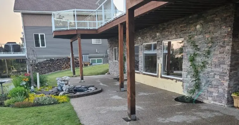 Wood beam supported by Postech Red Deer screw piles in a residential patio.