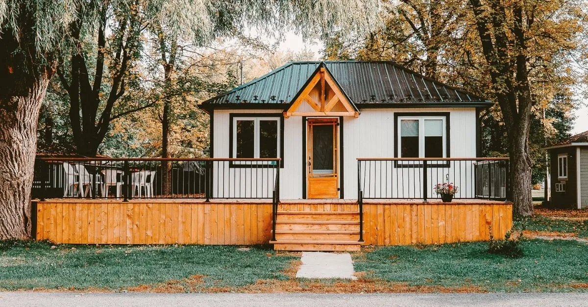 Cozy wooden deck surrounding a small cottage.